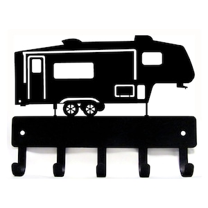 May include: Black metal key holder featuring a silhouette of a recreational vehicle. The key holder has four hooks below the RV design. The RV has windows, a door, and wheels. The key holder is mounted on a white background.