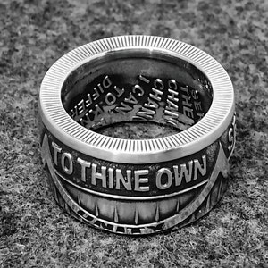 May include: A silver ring with the words "To Thine Own" engraved on the front. The inside of the ring has the words "I Can" and "See The Chain" engraved.