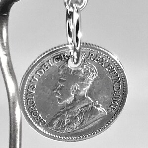 May include: Silver charm featuring a vintage Canadian coin with the profile of King George V and the inscription "GEORGIVS V DEI GRA REX ET IMP."