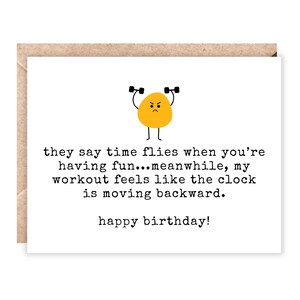 May include: A white greeting card with a brown envelope. The card features a yellow cartoon character lifting weights, with the text "they say time flies when you're having fun... meanwhile, my workout feels like the clock is moving backward. happy birthday!"