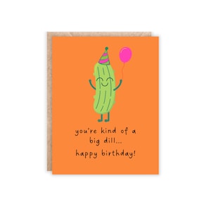 orange portrait size card. green pickle at the top with a silly face, holding a balloon and has a party hat on. text reads 'you're kind of a big dill...happy birthday