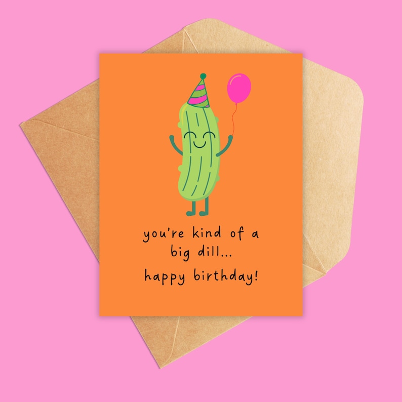 May include: A birthday card with a cartoon pickle character holding a pink balloon and wearing a party hat. The card has the text "you're kind of a big dill... happy birthday!" on an orange background, with a brown envelope.