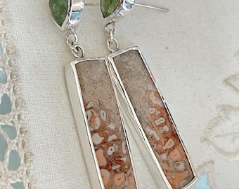 May include: A pair of silver dangle earrings with rectangular brown and orange agate stones and green gemstone accents.