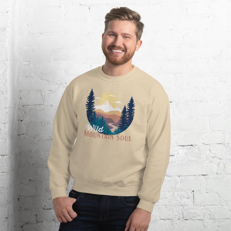 May include: A beige sweatshirt with a graphic of a mountain landscape and the text "Wild Mountain Soul".
