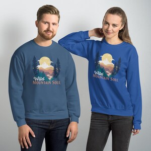 May include: Two sweatshirts with a mountain scene and the text "Wild Mountain Soul". One sweatshirt is blue and the other is dark blue.