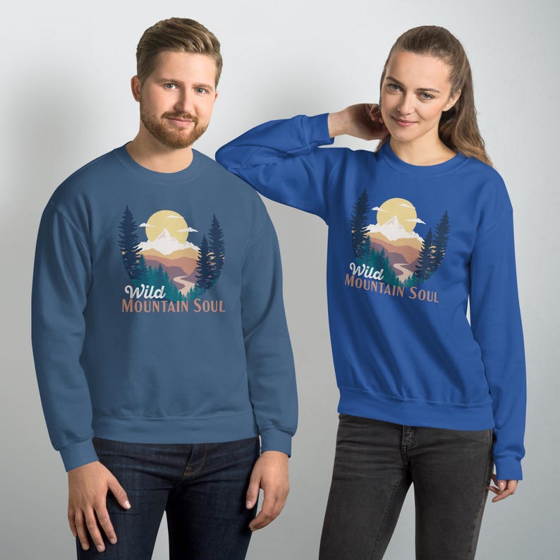 May include: Two sweatshirts with a mountain scene and the text "Wild Mountain Soul". One sweatshirt is blue and the other is dark blue.