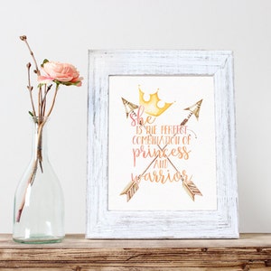 May include: A white framed print with a watercolour illustration of two crossed arrows with a gold crown and the text "She is the perfect combination of princess and warrior".
