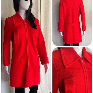 May include: A bright red knitted coat with a zipper closure, two flap pockets, and a contrasting trim around the collar and cuffs.