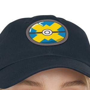 May include: A navy blue baseball cap with a yellow and blue Pokeball design.