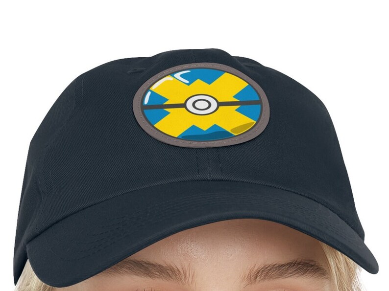 May include: A navy blue baseball cap with a yellow and blue Pokeball design.