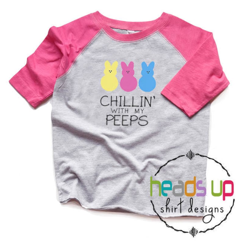 May include: A gray and pink raglan t-shirt with a graphic of three yellow, pink, and blue Peeps and the text "Chillin' with my peeps".
