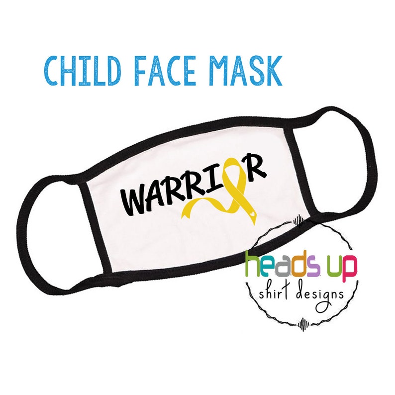 Op de afbeelding: Wit kindergezichtsmasker met zwarte elastische oorlussen. Het masker heeft een geel lint met het woord "WARRIOR" in het zwart gedrukt.