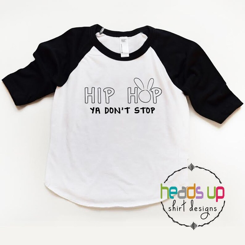 May include: White and black baseball tee shirt with the text "Hip Hop Ya Don't Stop" and a bunny rabbit graphic.