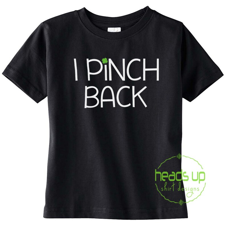 May include: Black t-shirt with white text that reads "I Pinch Back" and a green shamrock graphic.