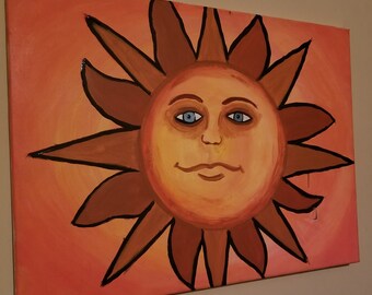 Puede incluir: Un lienzo pintado a mano representa un sol sonriente con una cara. El sol tiene una cara amarillo-naranja con ojos azules y un contorno marrón. Los rayos del sol son marrones con un contorno negro, sobre un fondo naranja degradado.