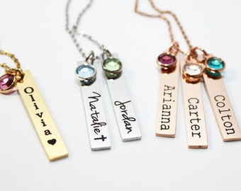 May include: Five personalized bar necklaces with different colored gemstones. The necklaces are gold, silver, and rose gold. The names on the bars are Olivia, Natalie, Jordan, Arianna, Carter, and Colton.