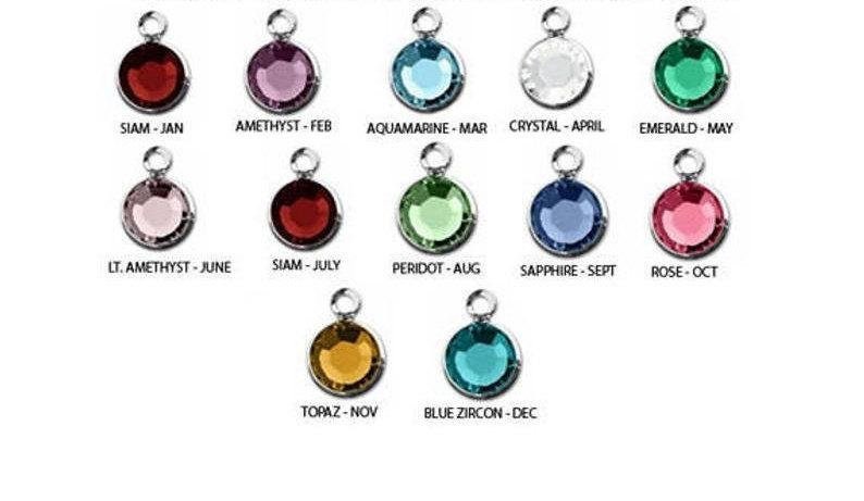 May include: Twelve round charms with different colored gemstones, each charm has a silver bail and a label with the gemstone name and corresponding month.  The gemstones are Siam, Amethyst, Aquamarine, Crystal, Emerald, Light Amethyst, Peridot, Sapphire, Rose, Topaz, and Blue Zircon.