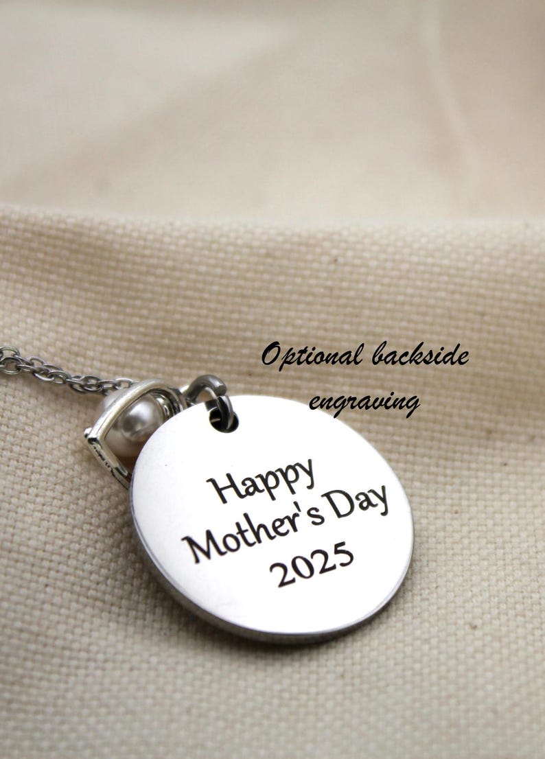 K&ouml;nnte beinhalten: Silberne Halskette mit einem runden Anh&auml;nger, auf dem "Happy Mother's Day 2025" steht. Der Anh&auml;nger hat einen kleinen Perlenanh&auml;nger. Optionale Gravur auf der R&uuml;ckseite.