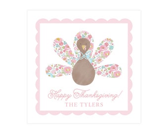 May include: A Thanksgiving-themed square card with a pink scalloped border. The card features a brown turkey with floral patterned feathers in pink, blue, and yellow. The text "Happy Thanksgiving!" and a name are in pink script.