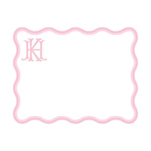 May include: A rectangular white card with a scalloped edge outlined in light pink. The card features a light pink monogram in the upper left corner consisting of the intertwined capital letters K and H in a decorative serif typeface.