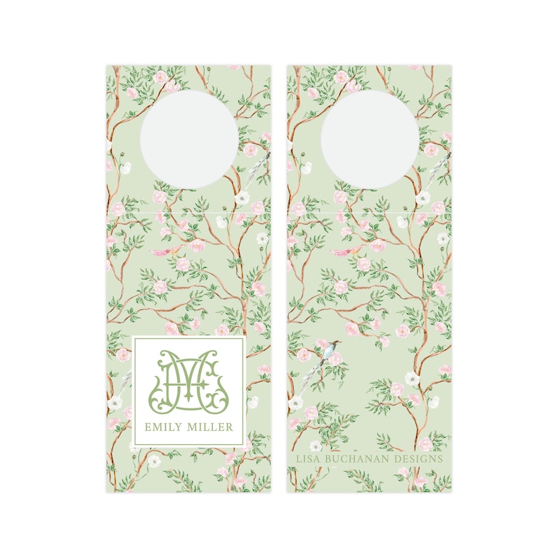 May include: Two green and white floral patterned bottle tags with a circle cut out for the neck of a bottle. The left tag has a monogram with the initials "EM" and the name "Emily Miller" printed below. The right tag has the text "Lisa Buchanan Designs" printed below the circle.