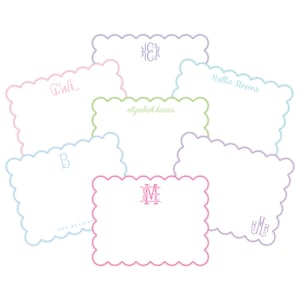 May include: A collection of seven rectangular note cards with scalloped edges, each featuring unique personalized monograms or names in various pastel colors including pink, light blue, lavender, and green, arranged in a layered cluster.