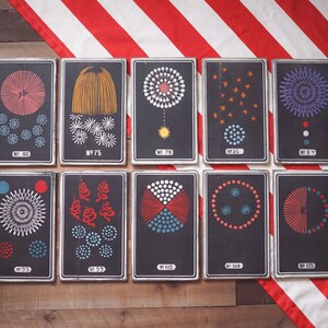 Peut inclure: Dix cartes encadr&eacute;es en noir et blanc avec diff&eacute;rents motifs de feux d'artifice. Chaque carte porte un num&eacute;ro et le mot "No." imprim&eacute; dessus. Les cartes sont dispos&eacute;es en deux rang&eacute;es de cinq.
