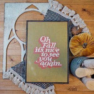 May include: A framed sign with a green background and red text that reads "Oh Fall, it's nice to see you again."