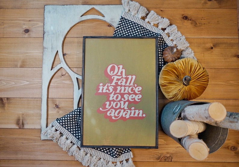 May include: A framed sign with a green background and red text that reads "Oh Fall, it's nice to see you again."