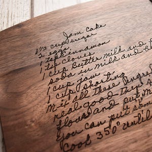 a wooden cutting board with handwritten text on it, along with some kitchen utensils and a bowl of sugar placed nearby.