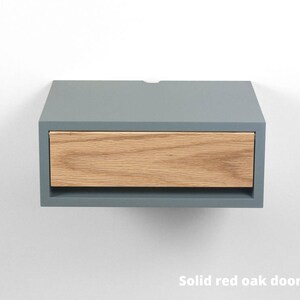 May include: A gray floating nightstand with a single drawer made of solid red oak wood.