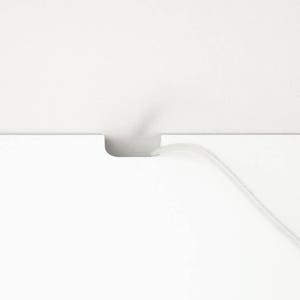 Puede incluir: Una superficie blanca con un corte para que pase un cable. Un cable blanco pasa a trav&eacute;s de la abertura.
