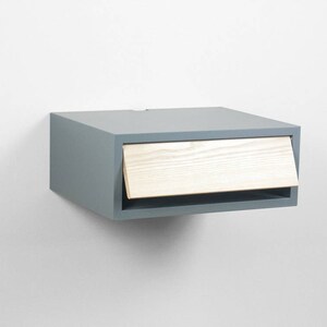 May include: A gray floating nightstand with a light wood drawer. The drawer is open and the wood grain is visible.