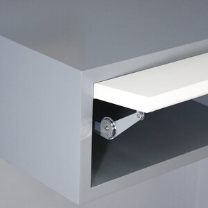 May include: A gray cabinet with a white shelf that is partially open. The shelf is attached to the cabinet with a silver hinge.