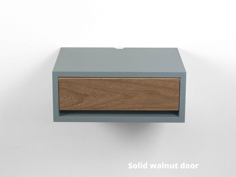 May include: A light blue floating nightstand with a single drawer made of solid walnut wood. The drawer is open and the wood grain is visible.