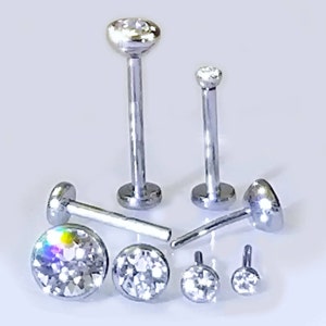 May include: A set of seven silver body jewelry pieces with clear crystal accents. The jewelry is made of surgical steel and is available in different sizes.