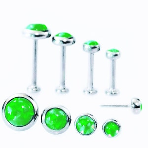 May include: A set of seven green opal body jewelry pieces in various sizes. The jewelry is made of surgical steel and features a round green opal stone.