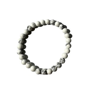 May include: White and black marbled stone bead bracelet. The bracelet is made of round beads and is approximately 7 inches in length.
