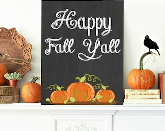 May include: A black chalkboard sign with white chalk lettering that reads "Happy Fall Y'all".  The sign is decorated with three orange pumpkins with green vines and leaves.