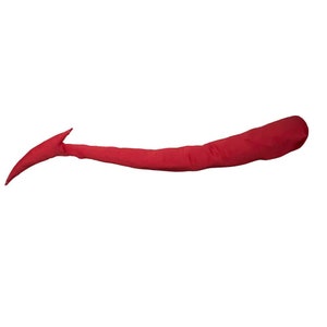 May include: A long, stuffed fabric tail in a solid deep red color. The object features a smooth, rounded base that tapers gradually toward a pointed, curved tip, resembling a stylized animal tail with a distinct fin-like shape at the end.