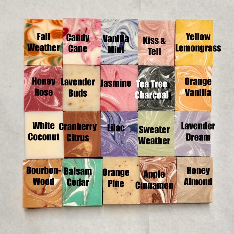 May include: A collection of 20 handmade soap bars with various scents and colors. The soap bars are arranged in a grid of four rows and five columns. The scents are labeled on each bar, including Fall Weather, Candy Cane, Vanilla Mint, Kiss & Tell, Yellow Lemongrass, Honey Rose, Lavender Buds, Jasmine, Tea Tree Charcoal, Orange Vanilla, White Coconut, Cranberry Citrus, Lilac, Sweater Weather, Lavender Dream, Bourbon Wood, Balsam Cedar, Orange Pine, Apple Cinnamon, and Honey Almond.