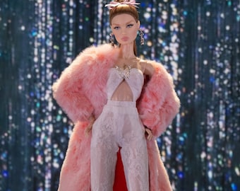 May include: A fashion doll wearing a pink fur coat over a white lace jumpsuit. The doll has long brown hair, a pink flower in her hair, and is wearing silver earrings.