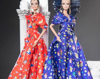 May include: Two dolls wearing long, patterned dresses. The doll on the left is wearing a red dress with a white and blue pattern. The doll on the right is wearing a blue dress with a white and yellow pattern.