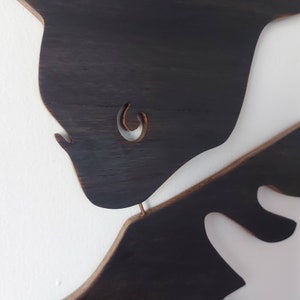Puede incluir: Dos piezas de arte de pared de madera marr&oacute;n oscuro en forma de figuras abstractas. La pieza superior tiene un recorte en forma de c&iacute;rculo.