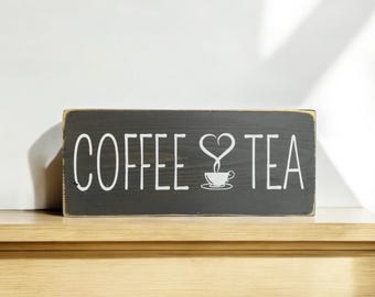 May include: A black wooden sign with white text that reads "COFFEE ♥ TEA" with a stylized coffee cup and steam in the shape of a heart.