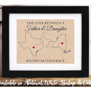 May include: A framed print on burlap fabric with a map of Texas and New York connected by a dotted line. The text reads "The love between a father & daughter knows no distance".