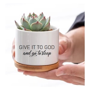 May include: White ceramic succulent planter with a bamboo base. The planter has the text "GIVE IT TO GOD and go to sleep" written on it.