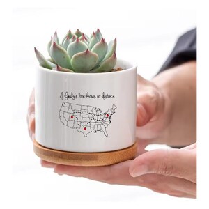 May include: White ceramic succulent planter with a map of the United States and the text "A family's love knows no distance".