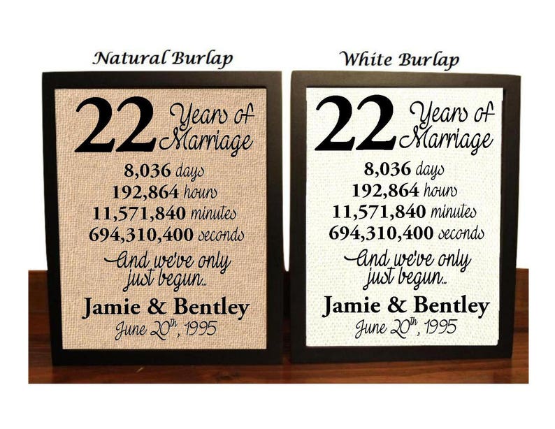 May include: Two framed signs with burlap backgrounds, one natural and one white, celebrating 22 years of marriage. The signs feature the number 22, the words "Years of Marriage", the number of days, hours, minutes, and seconds in 22 years, the phrase "And we've only just begun...", the names "Jamie & Bentley", and the date "June 20th, 1995".