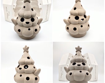 May include: A beige ceramic Christmas tree candle holder with a star on top and holes for candles. The tree has a smiling face and small arms. The candle holder is shown next to a white mold with the text "Happy Glow Tree" and "Hotcakesusa" on it.